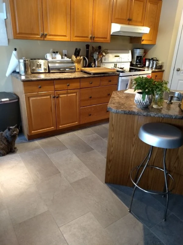 Modern kitchen interior featuring grey stone-look LVT flooring tiles