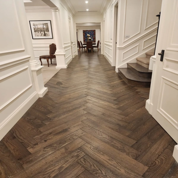 Premium dark oak SPC herringbone flooring installed in a luxury classic hallway with white wall molding.