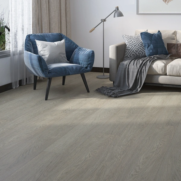 Weathered grey SPC Rigid Core Flooring in a contemporary bedroom with a grey armchair